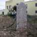 Tornando sul piazzale antistante la masseria scorgiamo in unaiuola un menhir tra due volute in ferro. Il millenario monolite fu rubato dalla tenuta nel 1994 poi essere recuperato e sistemato qui nel 2012